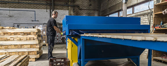 Medewerkers bedient machine voor het maken van pallets