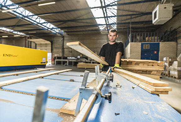 Medewerkers machinaal pallets in elkaar aan het zetten.