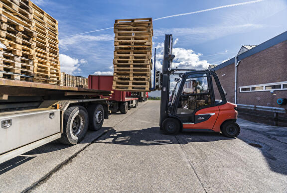 Heftruck laden van vrachtwagen met pallets.