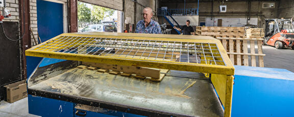 Medewerkers bij palletmachine