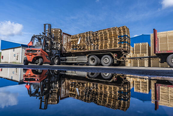 Vrachtwagen met paletten afgeladen met vorkheftruck