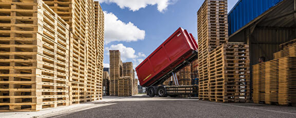 Het afladen van pallets voor vrachtwagen met kiepbak