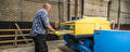 Medewerkers bedient machine voor pallets