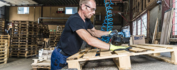 Medewerker pallets in mekaar aan het zetten.